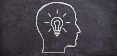 Kreidezeichnung auf Tafel - Umriss Kopf mit Glühbirne innerhalb