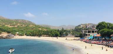 Bunte Fischerboote und Personen am weißen Sandstrand