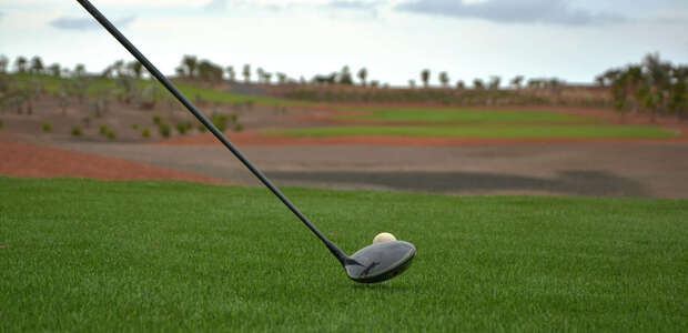 Golfschläger und Golfball auf dem grünen Rasen