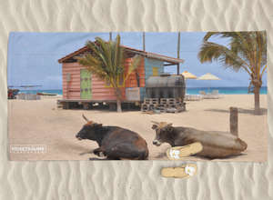 Bedrucktes Handtuch liegt im Sand neben FlipFlops