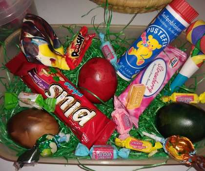 Osternest mit bunten Eiern, Süßigkeiten und Seifenblasen