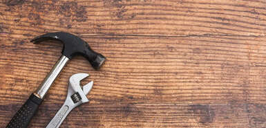 Hammer und Spannschlüssel auf Holz